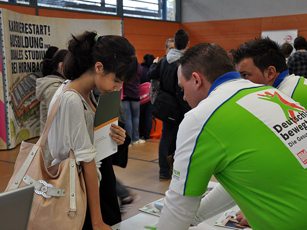Schülerin im Gespräch mit den Mitarbeitern der Barmer GEK